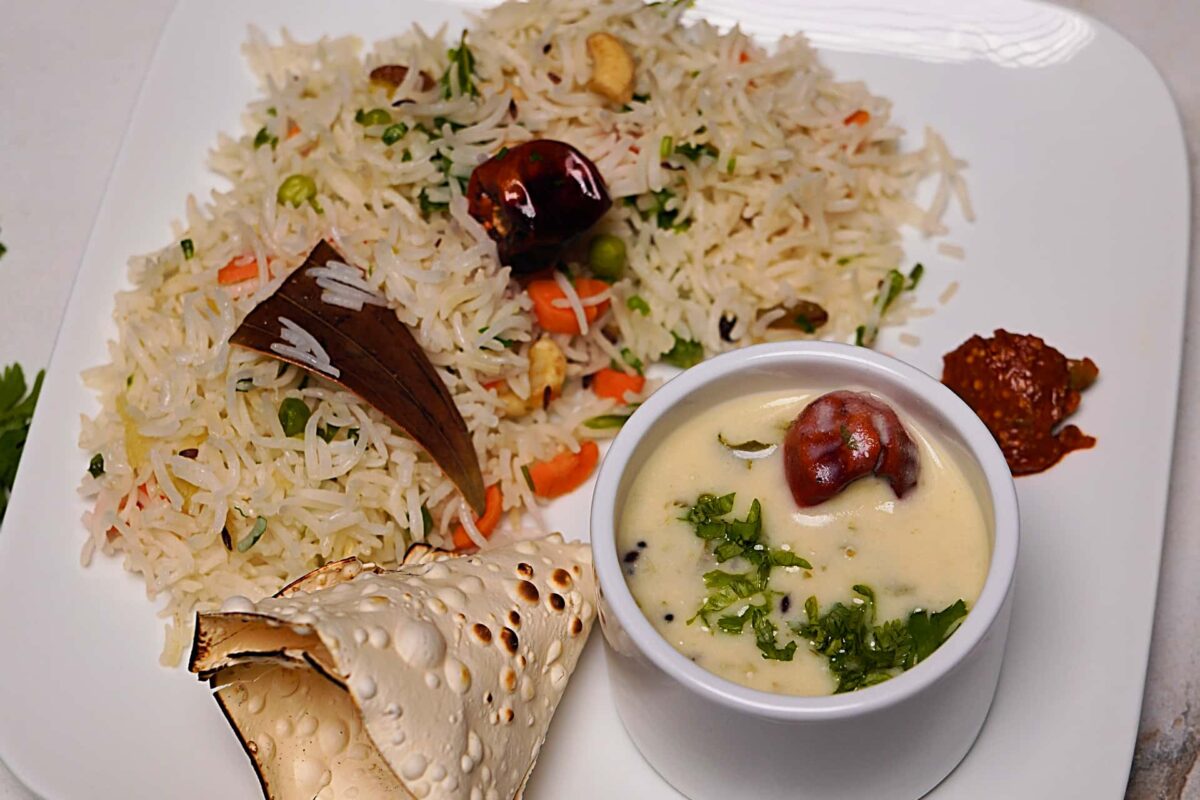 Traditional Gujarati Pulao and Kadhi served with fresh cilantro garnish, ready to be enjoyed