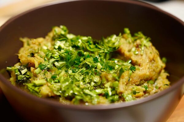 Baigan Bharta served with fresh coriander garnish in bowl revealing amazing texture