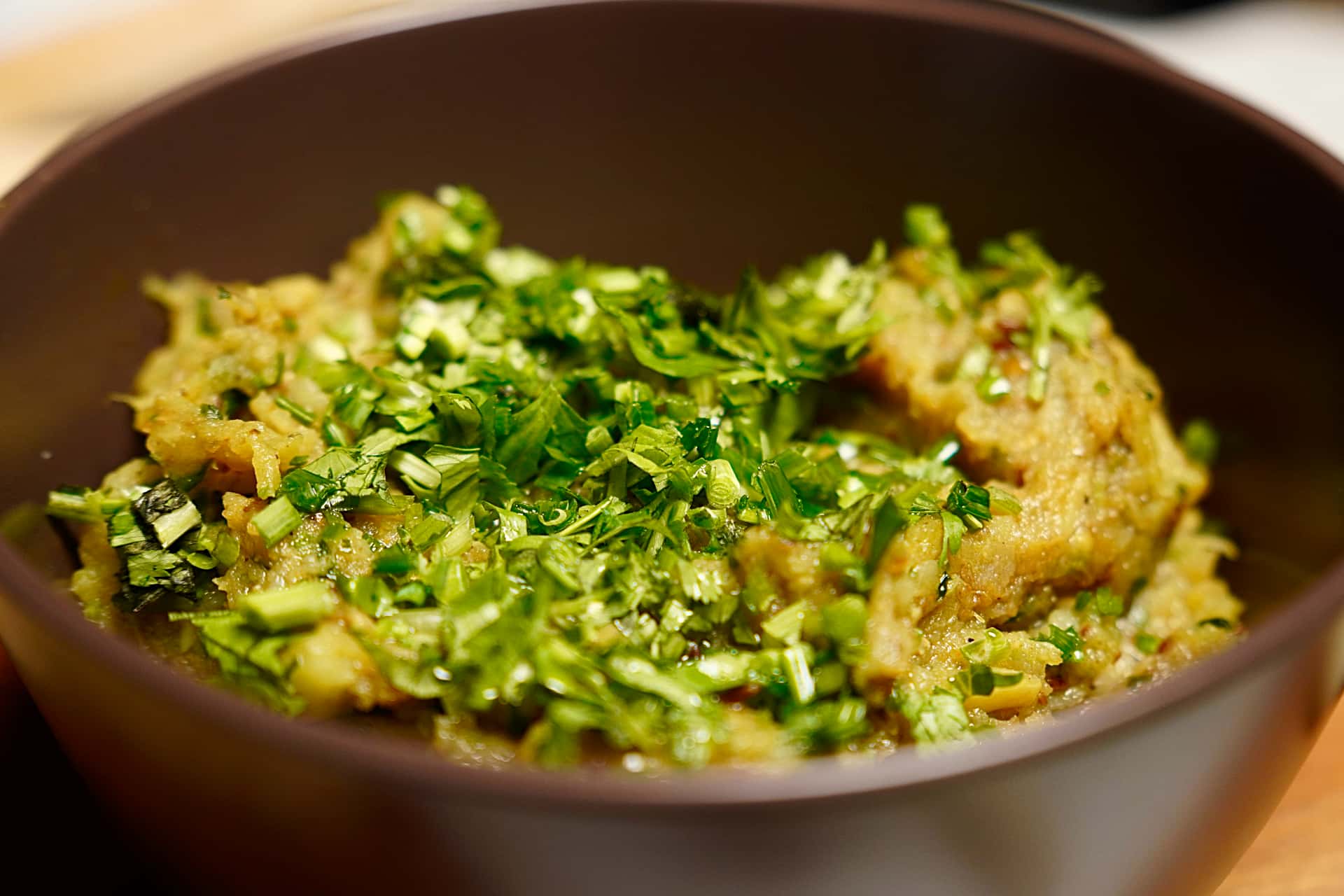 Baigan Bharta served with fresh coriander garnish in bowl revealing amazing texture