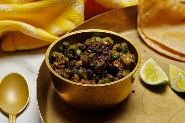 Bhinda nu Shaak served alongside warm roti and a slice of lime for added flavor.