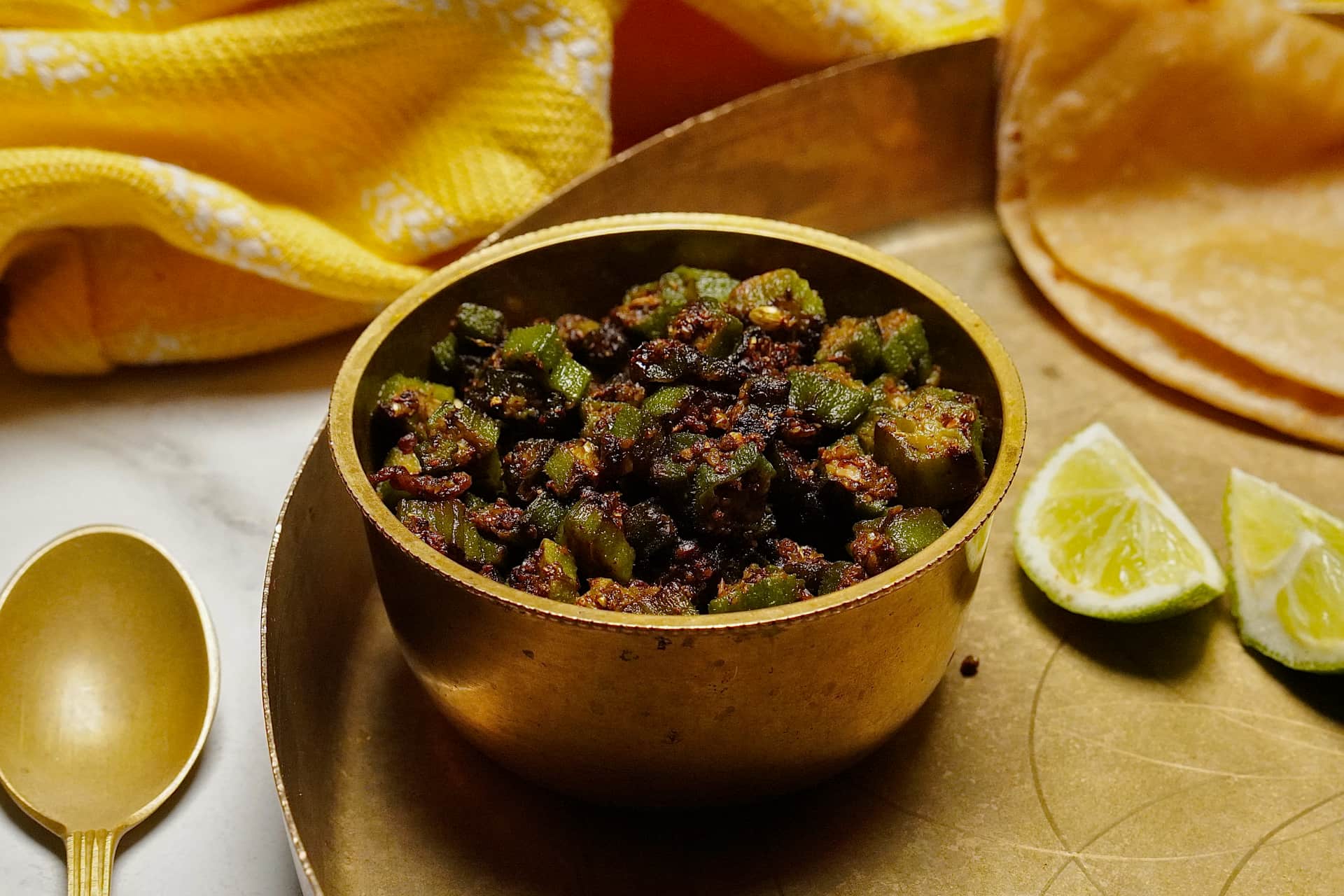 Bhinda nu Shaak served alongside warm roti and a slice of lime for added flavor.