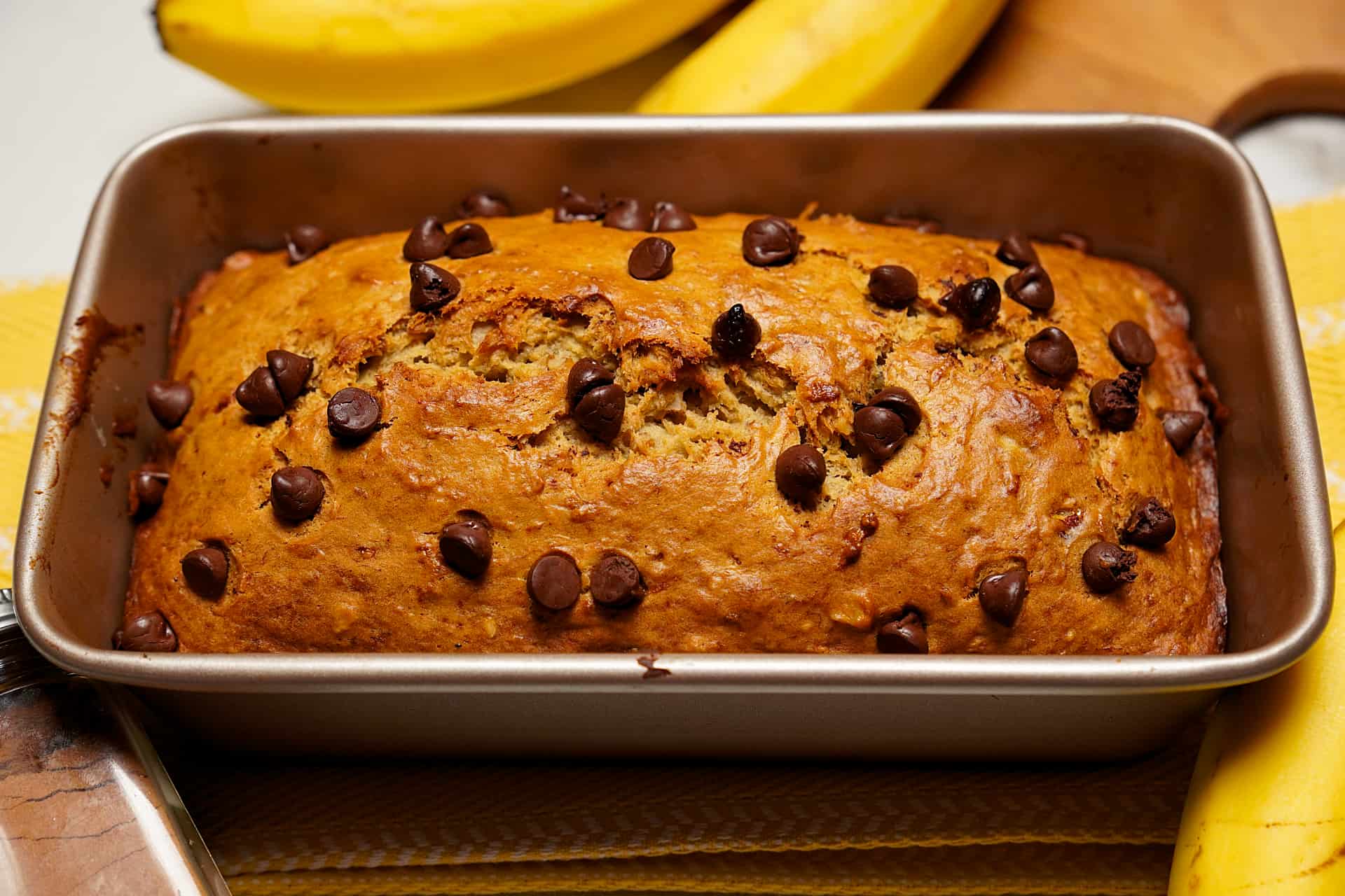 Whole loaf of freshly baked eggless banana bread in loaf pan