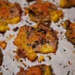 Crispy golden smashed potatoes with herbs and melted cheddar cheese