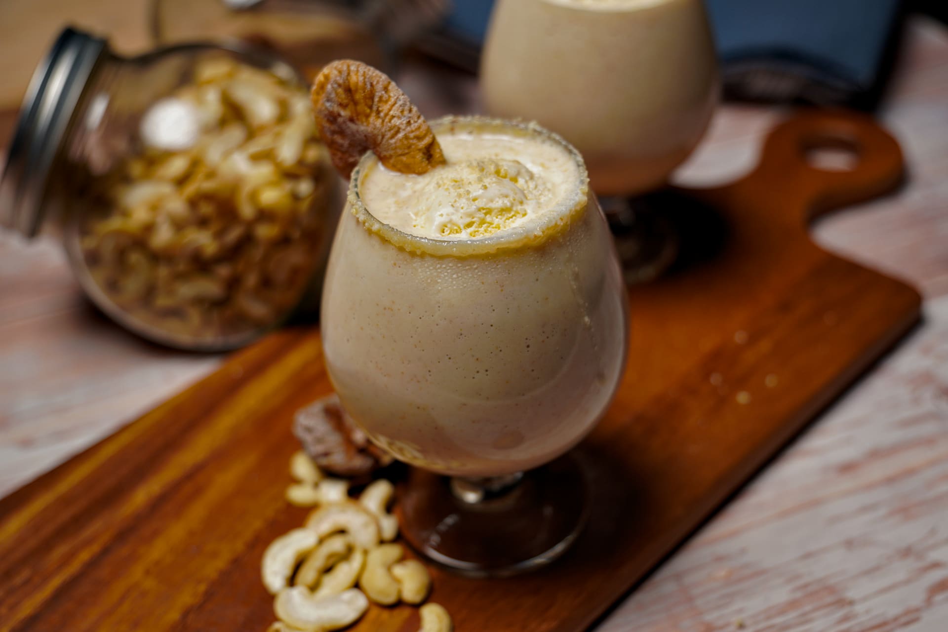 A refreshing Kaju Anjeer Milkshake served in a glass, garnished with a fig slice.