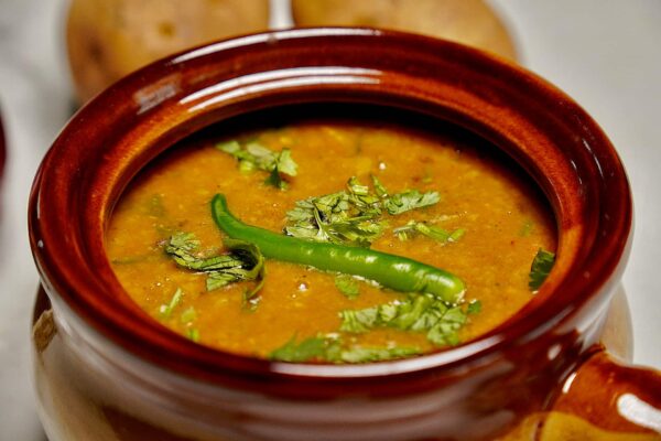 Close-up of Masala Dal in a traditional handi, capturing the rich texture and color.