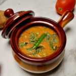 A flavorful Masala Dal with spices in a pot showcasing a rich texture.