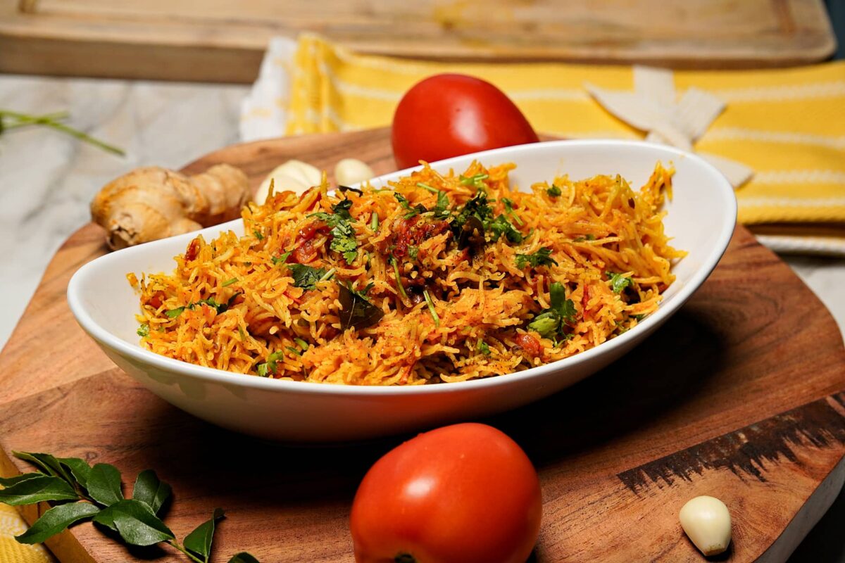 Delicious Tomato Rice served in a bowl, garnished with fresh coriander and a drizzle of ghee.