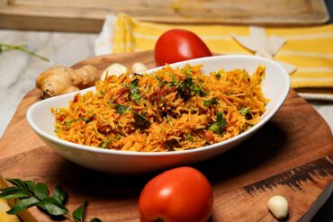 Delicious Tomato Rice served in a bowl, garnished with fresh coriander and a drizzle of ghee.