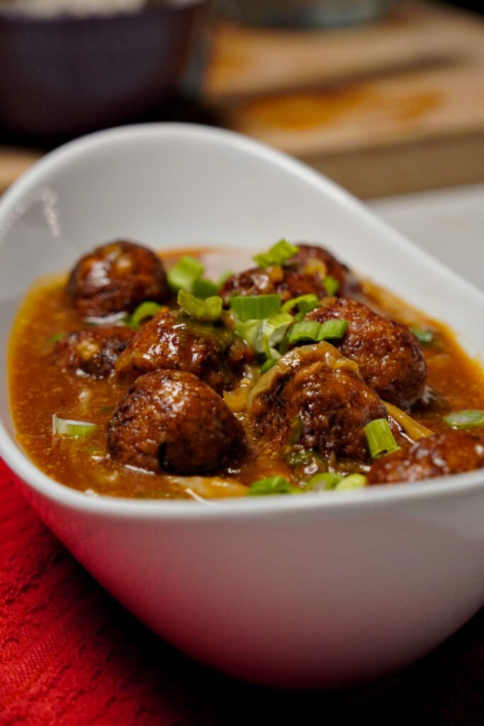 Golden brown vegetable balls in gravy served in bowl