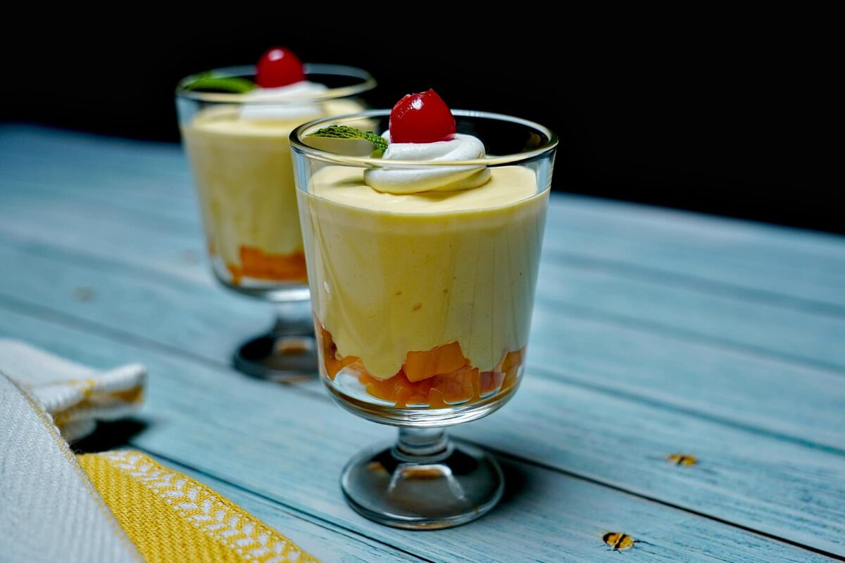 A beautifully plated Heavenly Mango Mousse served in elegant glasses, showcasing its creamy texture and vibrant color.