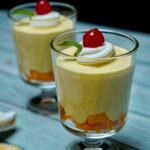 Close-up view of Heavenly Mango Mousse, highlighting the smooth and airy texture topped with whipped cream.
