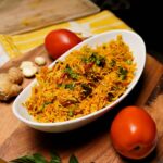 Cooked Tomato Rice with ingredients like tomatoes, ginger and curry leaves