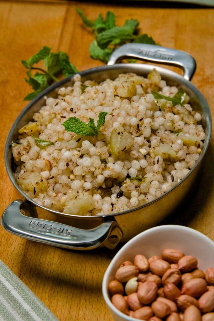 An extreme close-up of Sabudana Khichdi, highlighting the glossy, translucent pearls mixed with mint and spices.